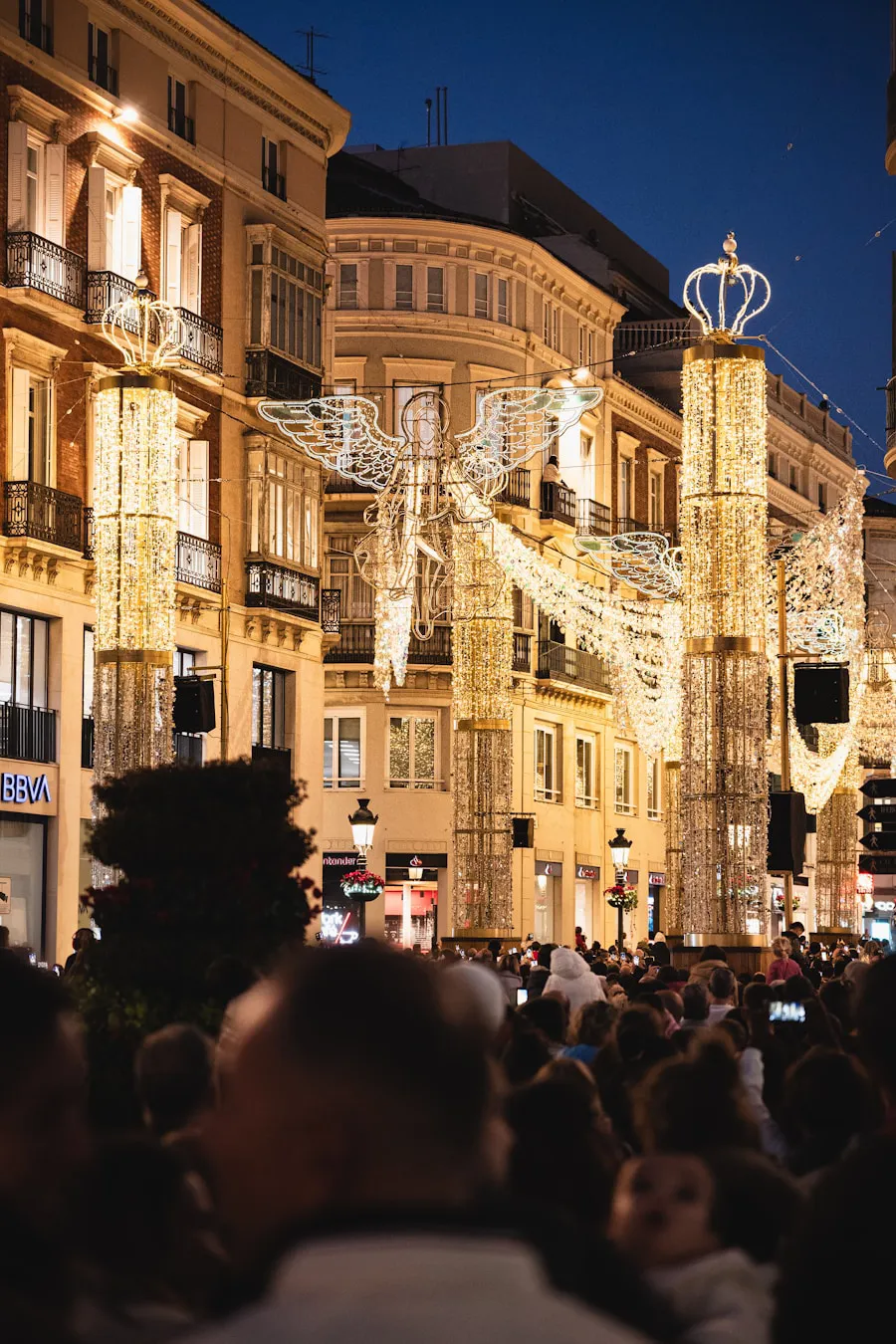 A city street glowing with Christmas lights at night